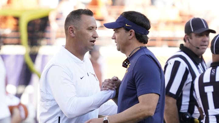 Texas Longhorns head coach Steve Sarkisian talks with West Virginia Mountaineers head coach Neal Brown before a game at Darrell K Royal-Texas Memorial Stadium.