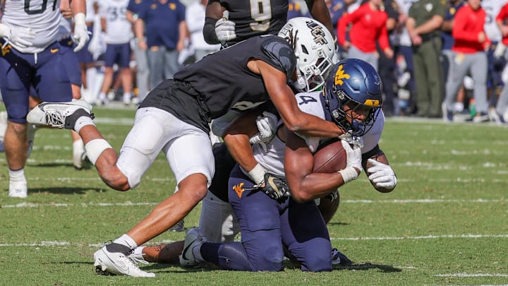 Oct 28, 2023; Orlando, Florida, USA; West Virginia Mountaineers running back CJ Donaldson Jr. (4) is tackled by UCF Knights defensive back Demari Henderson (8) during the second half at FBC Mortgage Stadium. Mandatory Credit: Mike Watters-Imagn Images Oct 28, 2023; Orlando, Florida, USA; West Virginia Mountaineers running back CJ Donaldson Jr. (4) is tackled by UCF Knights defensive back Demari Henderson (8) during the second half at FBC Mortgage Stadium. Mandatory Credit: Mike Watters-Imagn Images