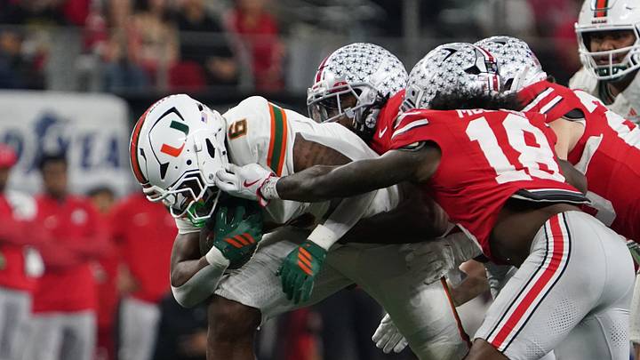 Dec 31, 2025; Arlington, TX, USA; Miami Hurricanes running back Charmar Brown (6) carries the ball as Ohio State Buckeyes safety Jaylen McClain (18) defends during second half the 2025 Cotton Bowl and quarterfinal game of the College Football Playoff at AT&T Stadium. Mandatory Credit: Raymond Carlin III-Imagn Images Dec 31, 2025; Arlington, TX, USA; Miami Hurricanes running back Charmar Brown (6) carries the ball as Ohio State Buckeyes safety Jaylen McClain (18) defends during second half the 2025 Cotton Bowl and quarterfinal game of the College Football Playoff at AT&T Stadium. Mandatory Credit: Raymond Carlin III-Imagn Images
