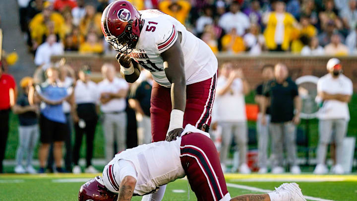 Oct 21, 2023; Columbia, Missouri, USA; South Carolina Gamecocks offensive lineman Tree Babalade (51) checks on quarterback Spencer Rattler (7) after a play during the second half against the Missouri Tigers at Faurot Field at Memorial Stadium. Mandatory Credit: Jay Biggerstaff-Imagn Images