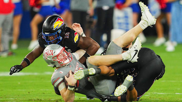 UNLV quarterback Matthew Sluka is tackled by Kansas linebacker Tristian Fletcher (19) and defensive end Dean Miller. UNLV quarterback Matthew Sluka is tackled by Kansas linebacker Tristian Fletcher (19) and defensive end Dean Miller.