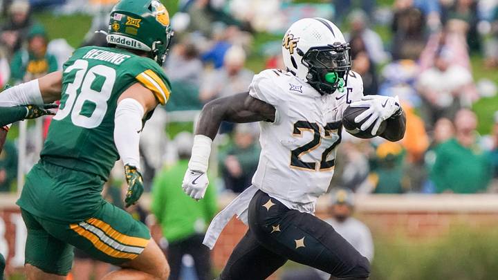 Nov 1, 2025; Waco, Texas, USA; UCF Knights running back Myles Montgomery (22) carries the ball as Baylor Bears safety Jacob Redding (38) defends during the first half at McLane Stadium. Mandatory Credit: Raymond Carlin III-Imagn Images