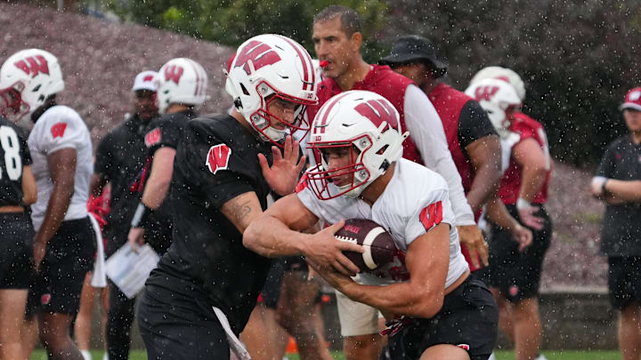 Wisconsin running back Harrison Bortolotti (32) takes a handoff from quarterback Hunter Simmons (15) during football practice, July 30, 2025, at Ralph E. Davis Pioneer Stadium in Platteville, Wisconsin.