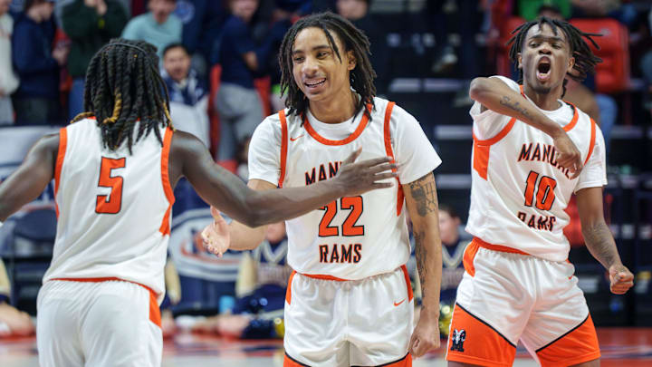 Manual's Reggie Postlewaite (5), Josh Humbles (22) and Jaquan Brown celebrate as time runs out on their 60-55 win over Quincy Notre Dame in the Class 2A boys high school state basketball championship game Saturday, March 14, 2026, at the State Farm Center in Champaign.