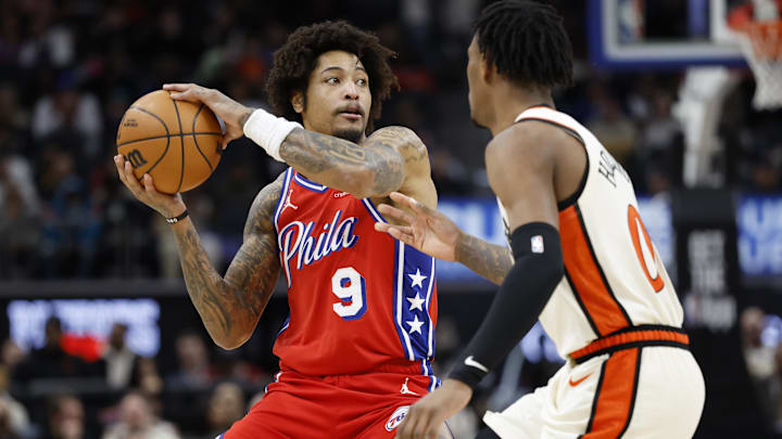 Feb 7, 2025; Detroit, Michigan, USA;  Philadelphia 76ers guard Kelly Oubre Jr. (9) is defended by Detroit Pistons forward Ronald Holland II (00) in the first half at Little Caesars Arena. Mandatory Credit: Rick Osentoski-Imagn Images