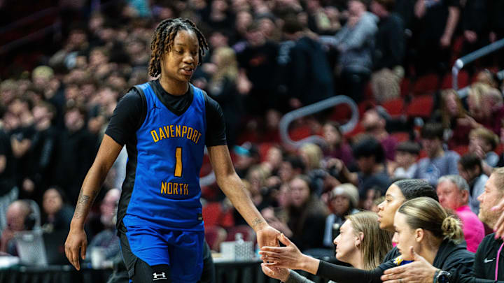 Davenport North's Divine Bourrage (1) high fives her teammates as she's subbed out during the third quarter of the Class 5A quarterfinal on Monday, March 3, 2025, at Wells Fargo Arena.