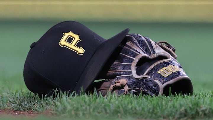 Sep 16, 2025; Pittsburgh, Pennsylvania, USA; A hat and glove belonging to Pittsburgh Pirates third baseman Jared Triolo (not pictured) on the field against the Chicago Cubs during the sixth inning at PNC Park. Mandatory Credit: Charles LeClaire-Imagn Images