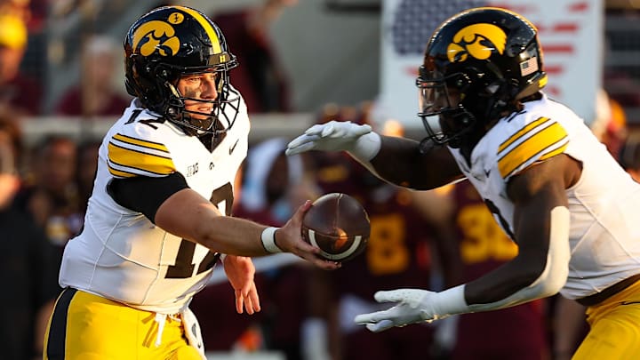 Sep 21, 2024; Minneapolis, Minnesota, USA; Iowa Hawkeyes quarterback Cade McNamara (12) hands the ball off to running back Kaleb Johnson (2) during the first half against the Minnesota Golden Gophers at Huntington Bank Stadium. Mandatory Credit: Matt Krohn-Imagn Images