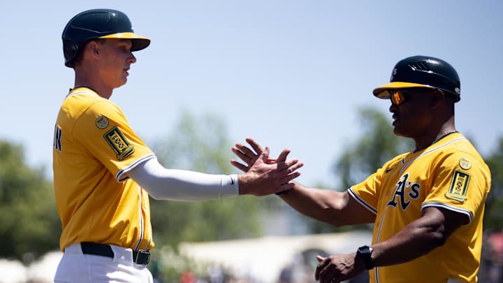May 25, 2025; West Sacramento, California, USA; Athletics first baseman Logan Davidson (6) gets a congratulatory handshake from third base coach Eric Martins after getting his first hit and RBI against the Philadelphia Phillies during the first inning at Sutter Health Park. Mandatory Credit: D. Ross Cameron-Imagn Images