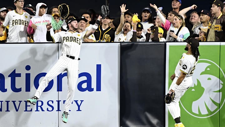 Oct 9, 2024; San Diego, California, USA; San Diego Padres outfielder Jackson Merrill (3) makes a catch against the wall in front of outfielder Fernando Tatis Jr. (23) in the fourth inning against the Los Angeles Dodgers during game four of the NLDS for the 2024 MLB Playoffs at Petco Park.  Mandatory Credit: Denis Poroy-Imagn Images