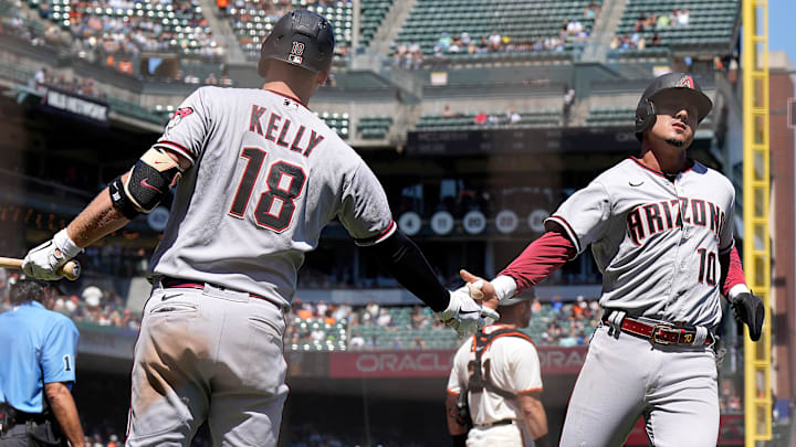 Josh Rojas slapping hands with Carson Kelly after scoring for the Arizona Diamondbacks
