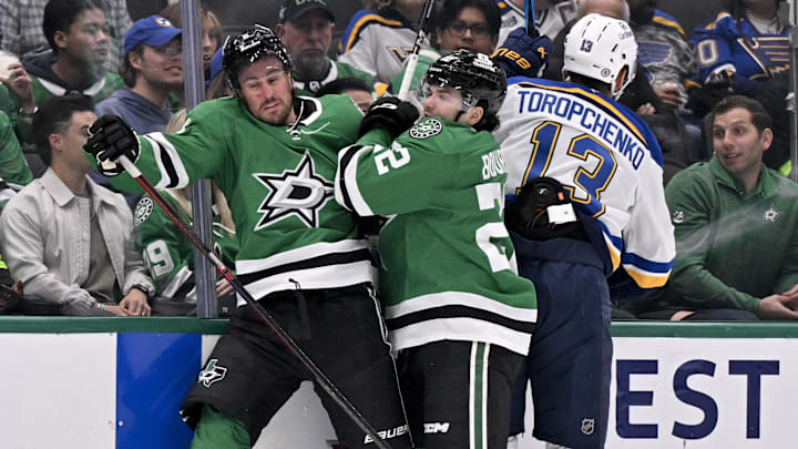 Mar 2, 2025; Dallas, Texas, USA; Dallas Stars defenseman Brendan Smith (2) and center Mavrik Bourque (22) and St. Louis Blues right wing Alexey Toropchenko (13) crash into the boards during the first period at the American Airlines Center. Mandatory Credit: Jerome Miron-Imagn Images