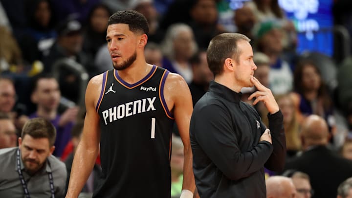 Nov 21, 2025; Phoenix, Arizona, USA; Phoenix Suns head coach Jordan Ott (left) with guard Devin Booker (1) against the Minnesota Timberwolves in the second half of an NBA Cup game at Mortgage Matchup Center. Mandatory Credit: Mark J. Rebilas-Imagn Images