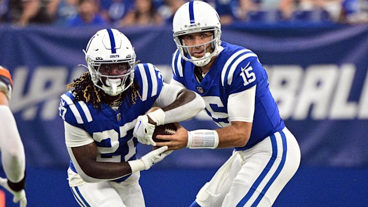 Aug 11, 2024; Indianapolis, Indiana, USA;  Indianapolis Colts quarterback Joe Flacco (15) hands the ball off to Indianapolis Colts running back Trey Sermon (27) during the first quarter at Lucas Oil Stadium. Mandatory Credit: Marc Lebryk-Imagn Images