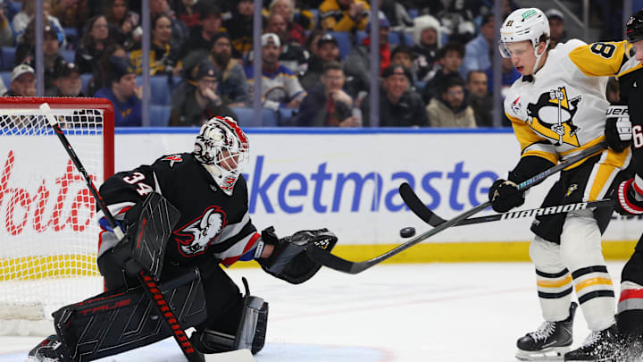 Feb 5, 2026; Buffalo, New York, USA;  Pittsburgh Penguins center Ben Kindel (81) tries to deflect a shot on Buffalo Sabres goaltender Alex Lyon (34) during the third period at KeyBank Center. Mandatory Credit: Timothy T. Ludwig-Imagn Images