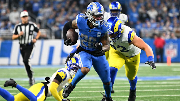 Jan 14, 2024; Detroit, Michigan, USA; Detroit Lions running back Jahmyr Gibbs (26) runs against Los Angeles Rams defensive end Jonah Williams (92) during the first half of a 2024 NFC wild card game at Ford Field. Mandatory Credit: Lon Horwedel-Imagn Images