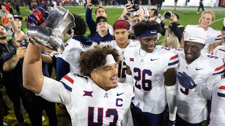Nov 28, 2025; Tempe, Arizona, USA; Arizona Wildcats defensive back Dalton Johnson (43) celebrates with the Territorial Cup trophy after defeating the Arizona State Sun Devils in the 99th Territorial Cup at Mountain America Stadium. Mandatory Credit: Mark J. Rebilas-Imagn Images