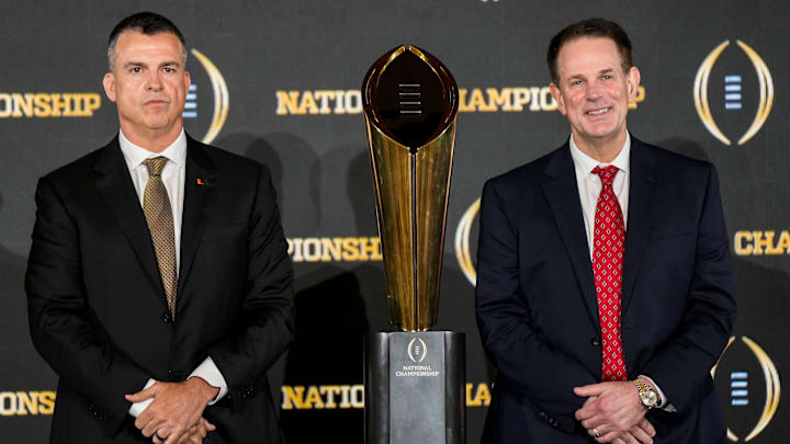 Miami Hurricanes head coach Mario Cristobal (left) and Indiana Hoosiers head coach Curt Cignetti pose for a photo Sunday, Jan. 18, 2026, during a press conference ahead of the College Football Playoff Championship in Miami.