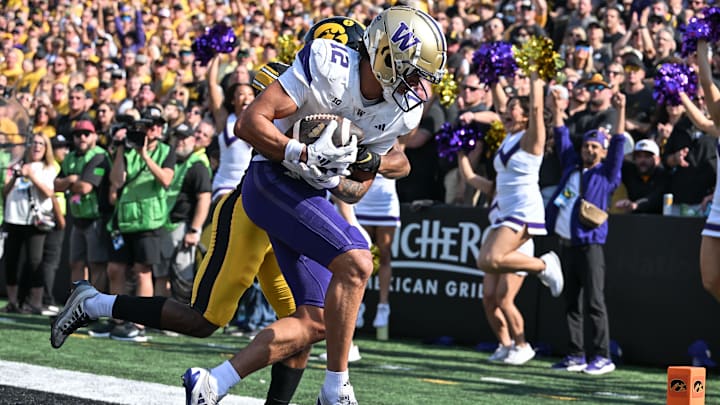 Oct 12, 2024; Iowa City, Iowa, USA; Washington Huskies wide receiver Denzel Boston (12) catches a touchdown pass as Iowa Hawkeyes defensive back Deshaun Lee (rear) defends during the second quarter at Kinnick Stadium. Mandatory Credit: Jeffrey Becker-Imagn Images