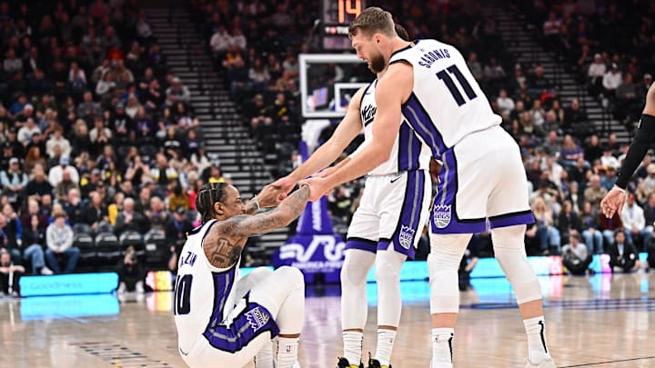 Feb 26, 2025; Salt Lake City, Utah, USA;  Sacramento Kings guard DeMar DeRozan (10) is helped up by teammates guard Zach LaVine (8) and forward Domantas Sabonis (11) in the first half against the Utah Jazz at Delta Center. Mandatory Credit: Jamie Sabau-Imagn Images