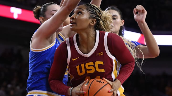 Feb 13, 2025; Los Angeles, California, USA; USC Trojans forward Kiki Iriafen (44) drives to the basket as UCLA Bruins forward Angela Dugalic (left) and UCLA Bruins center Lauren Betts (51) defend during the third quarter at Galen Center. Mandatory Credit: Robert Hanashiro-Imagn Images