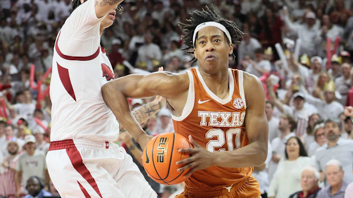 Feb 26, 2025; Fayetteville, Arkansas, USA; Texas Longhorns guard Tre Johnson (20) drives against Arkansas Razorbacks forward Trevon Brazile (4) during overtime at Bud Walton Arena. Mandatory Credit: Nelson Chenault-Imagn Images