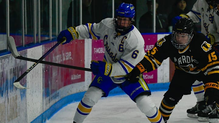 St. Cloud Cathedral hockey senior John Hirschfeld fights to keep possession of the puck against Warroad's Taven James in the 2024 season opener Nov. 23 at the Municipal Athletic Complex. The Crusaders and Warriors tied 2-2.