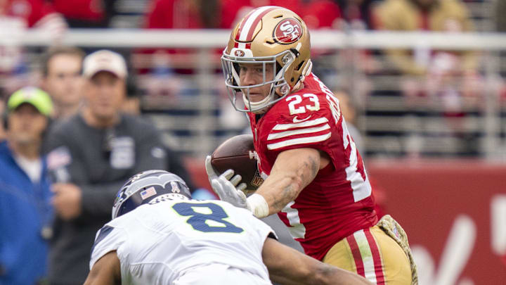 November 17, 2024; Santa Clara, California, USA; San Francisco 49ers running back Christian McCaffrey (23) runs against Seattle Seahawks cornerback Coby Bryant (8) during the second quarter at Levi's Stadium. Mandatory Credit: Kyle Terada-Imagn Images