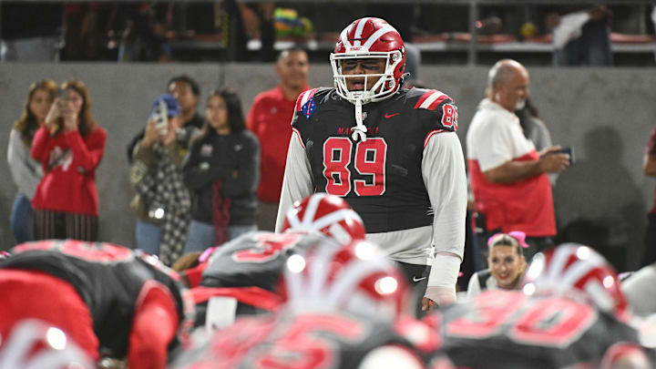 Mater Dei DL Semi Taulanga leads the Monarchs in pregame exercises before the Monarchs' 59-14 win over St. John Bosco at Santa Ana Stadium on Oct. 25, 2024 