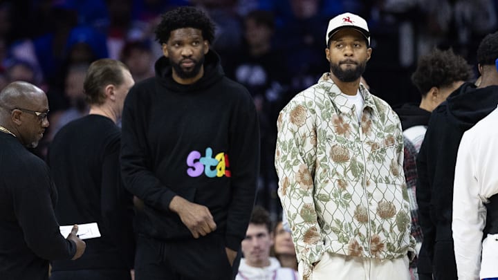 Nov 2, 2024; Philadelphia, Pennsylvania, USA; Injured Philadelphia 76ers Paul George (R) and Joel Embiid (L) look on during the first quarter against the Memphis Grizzlies at Wells Fargo Center. Mandatory Credit: Bill Streicher-Imagn Images