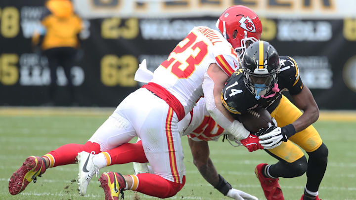 Dec 25, 2024; Pittsburgh, Pennsylvania, USA;  Pittsburgh Steelers wide receiver George Pickens (14) is tackled after a catch by Kansas City Chiefs linebacker Drue Tranquill (23) and safety Justin Reid (20) during the second quarter at Acrisure Stadium. Mandatory Credit: Charles LeClaire-Imagn Images