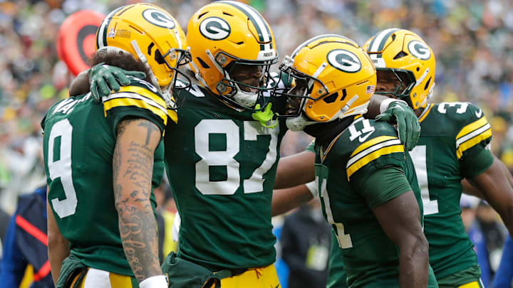 Green Bay Packers wide receiver Romeo Doubs (87) celebrates scoring a touchdown with wide receiver Christian Watson (9), wide receiver Jayden Reed (11), and running back Emanuel Wilson (31).