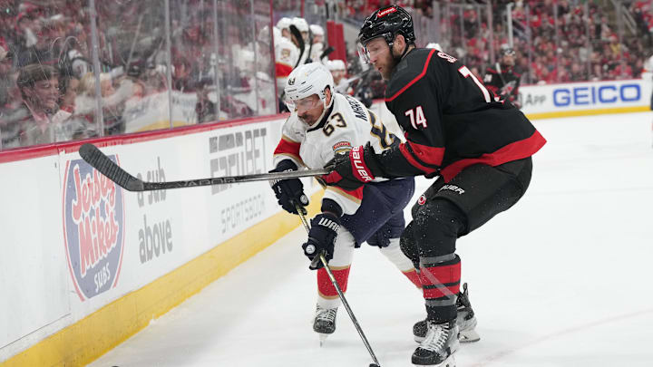 May 20, 2025; Raleigh, North Carolina, USA; Carolina Hurricanes defenseman Jaccob Slavin (74) defends against Florida Panthers forward Brad Marchand (63) during the second period in game one of the Eastern Conference Final of the 2025 Stanley Cup Playoffs at Lenovo Center. Mandatory Credit: James Guillory-Imagn Images