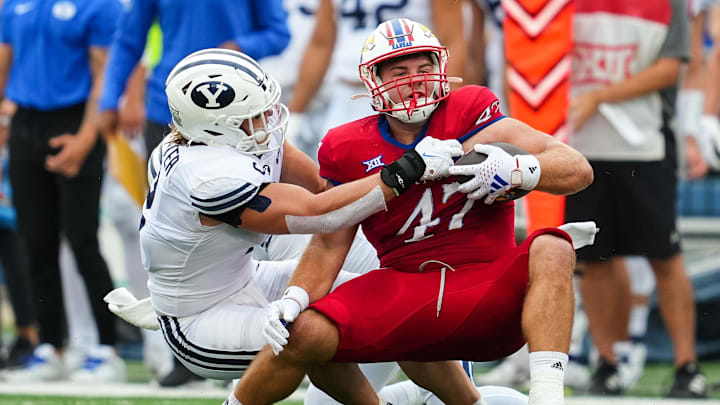 Sep 23, 2023; Lawrence, Kansas, USA; Kansas Jayhawks tight end Jared Casey (47) is tackled by Brigham Young Cougars linebacker Ben Bywater (2) during the first half at David Booth Kansas Memorial Stadium. Mandatory Credit: Jay Biggerstaff-Imagn Images