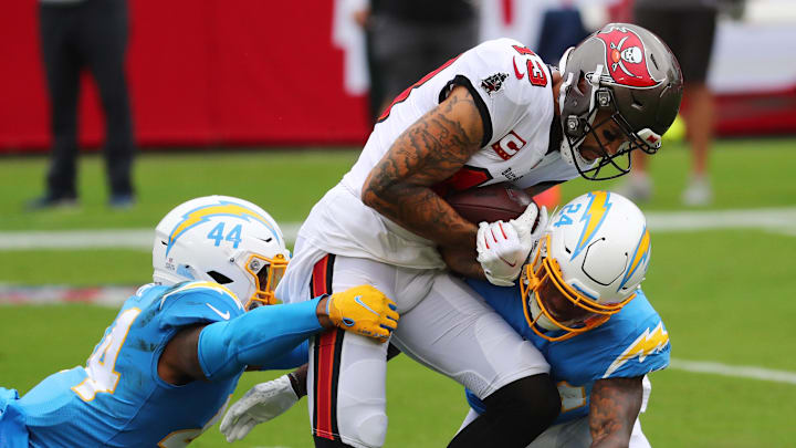 Oct 4, 2020; Tampa, Florida, USA; Tampa Bay Buccaneers wide receiver Mike Evans (13) is tackled by Los Angeles Chargers outside linebacker Kyzir White (44) and free safety Nasir Adderley (24) in the first quarter of a NFL game at Raymond James Stadium. Mandatory Credit: Kim Klement-Imagn Images