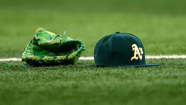 Jul 22, 2025; Arlington, Texas, USA;  Athletics glove and hat on the field before the game against the Texas Rangers at Globe Life Field. Mandatory Credit: Kevin Jairaj-Imagn Images