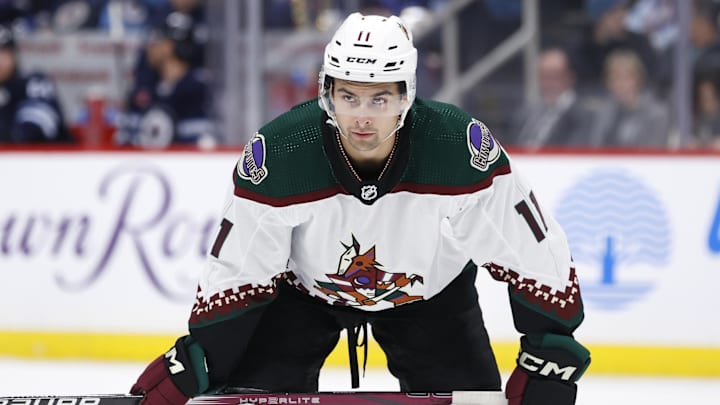 Feb 25, 2024; Winnipeg, Manitoba, CAN; Arizona Coyotes right wing Dylan Guenther (11) waits for a face off in the second period against the Winnipeg Jets at Canada Life Centre. Mandatory Credit: James Carey Lauder-Imagn Images