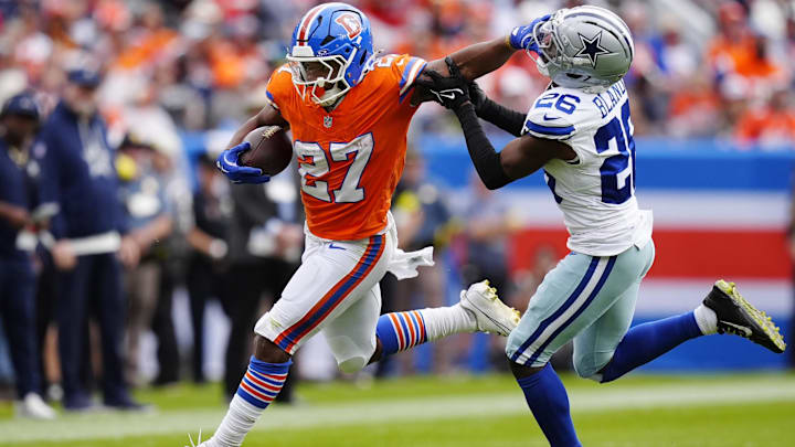 Denver Broncos running back J.K. Dobbins runs against Dallas Cowboys cornerback DaRon Bland. Denver Broncos running back J.K. Dobbins runs against Dallas Cowboys cornerback DaRon Bland.