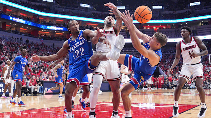 Kansas Jayhawks guard Darryn Peterson (22) and Kansas Jayhawks guard Kohl Rosario (7) surround Louisville Cardinals guard J'Vonne Hadley (1) as the trio battle for a loose ball during an exhibition game at the KFC Yum! Center in Louisville, Kentucky Friday, October 24, 2025.
