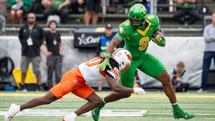 Oregon tight end Jamari Johnson attempts to outrun a tackle by Oklahoma State cornerback Kale Smith as the Oregon Ducks host the Oklahoma State Cowboys on Sept. 6, 2025, at Autzen Stadium in Eugene, Oregon.