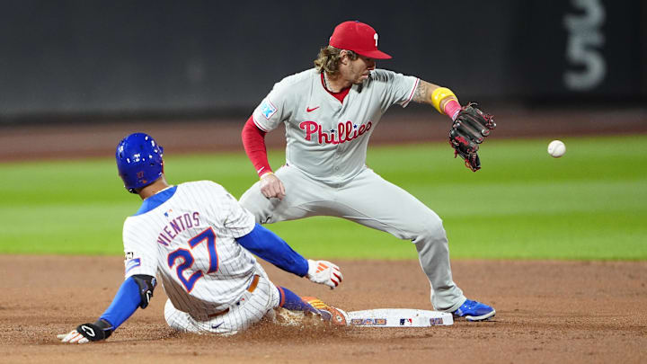 New York Mets third baseman Mark Vientos slides into second base with a double ahead of the throw received by Philadelphia Phillies second baseman Bryson Stott