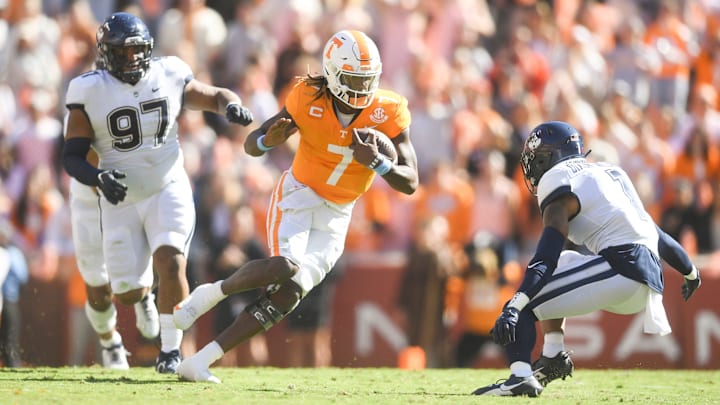 Tennessee quarterback Joe Milton III (7) scrambles with the ball while defended by UConn defensive