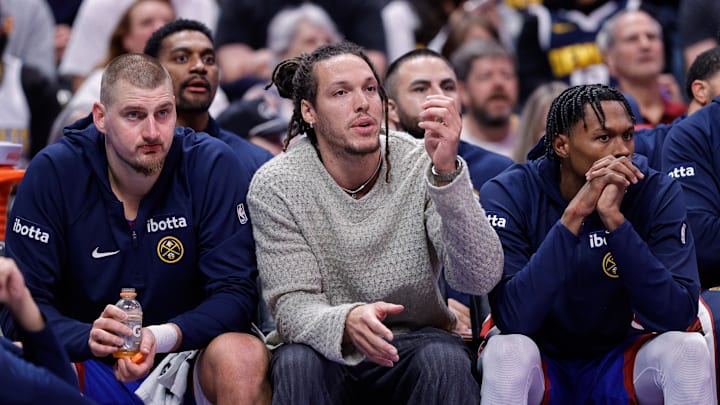 Nov 28, 2025; Denver, Colorado, USA; Denver Nuggets forward Aaron Gordon (C) looks on from the bench with center Nikola Jokic (15) and guard Peyton Watson (8) in the fourth quarter against the San Antonio Spurs at Ball Arena.