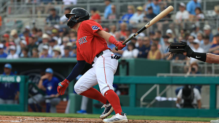 Feb 22, 2026; Fort Myers, Florida, USA;  Boston Red Sox infielder Caleb Durbin (17) hits an RBI single during the first inning against the Toronto Blue Jays at JetBlue Park at Fenway South. Mandatory Credit: Kim Klement Neitzel-Imagn Images