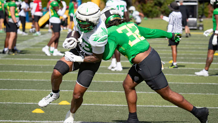 Oregon tight end Roger Saleapaga carries the ball under coverage from linebacker Emar'rion Winston during practice with the Oregon Ducks Tuesday, Aug. 20, 2024 at the Hatfield-Dowlin Complex in Eugene, Ore.