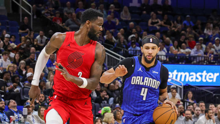 Apr 1, 2024; Orlando, Florida, USA; Orlando Magic guard Jalen Suggs (4) brings the ball up court against Portland Trail Blazers center Deandre Ayton (2) during the second half at Amway Center. Mandatory Credit: Mike Watters-Imagn Images
