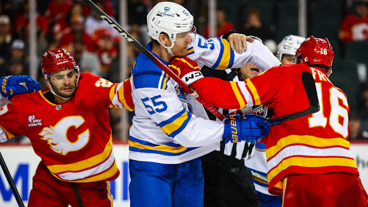 Mar 18, 2026; Calgary, Alberta, CAN; St. Louis Blues defenseman Colton Parayko (55) and Calgary Flames center Morgan Frost (16) get into a scrum during the overtime period at Scotiabank Saddledome. Mandatory Credit: Sergei Belski-Imagn Images