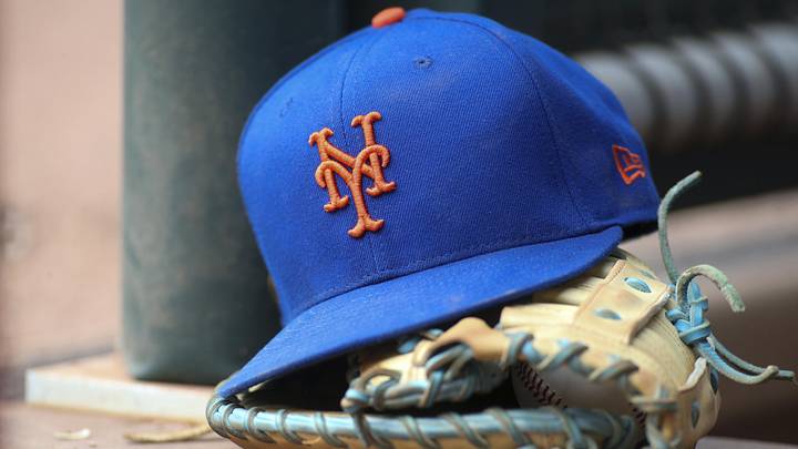 Jul 13, 2022; Atlanta, Georgia, USA; A detailed view of a New York Mets hat and glove in the dugout against the Atlanta Braves in the eighth inning at Truist Park. 