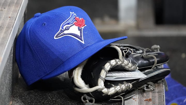 Apr 16, 2025; Toronto, Ontario, CAN; A Toronto Blue Jays hat and glove in the dugout during a game against the Atlanta Braves at Rogers Centre. Mandatory Credit: John E. Sokolowski-Imagn Images