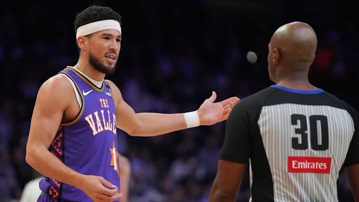 Nov 18, 2024; Phoenix, Arizona, USA; Phoenix Suns guard Devin Booker (1) talks to referee John Butler (30) during the first half of an NBA game against the Orlando Magic at Footprint Center. Mandatory Credit: Rick Scuteri-Imagn Images
